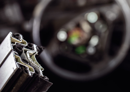 Närbild av metall- och gummiprofiler, med suddig bakgrund.